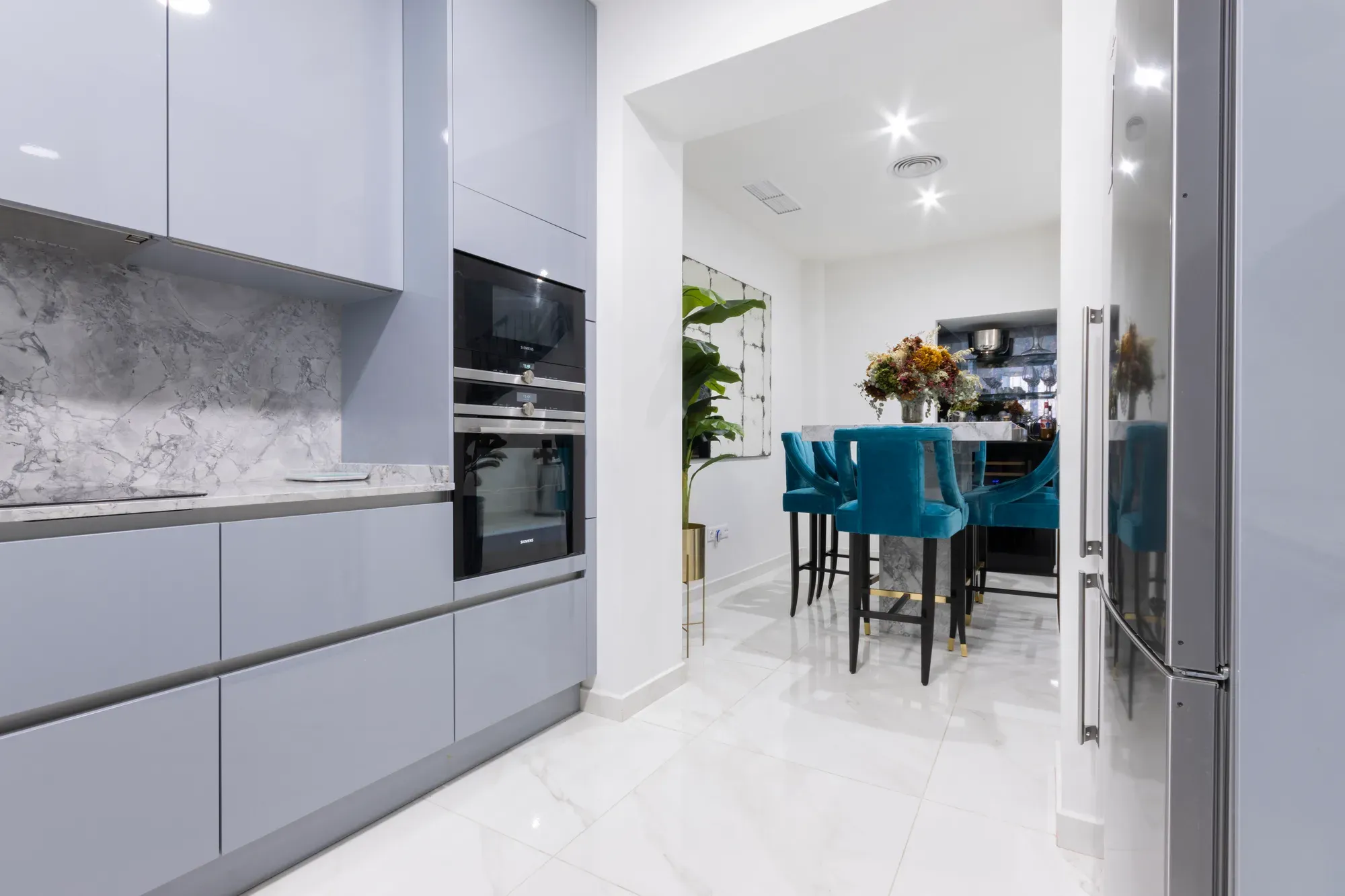 Cocina reformada en gris abierta al comedor, con horno y microondas en columna