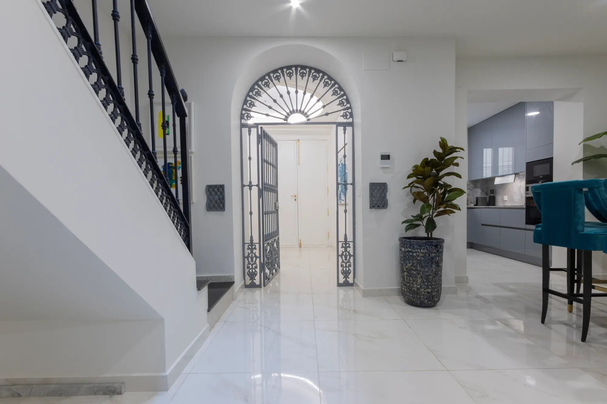 Salón reformado de doble altura con sofá azul y ventanal