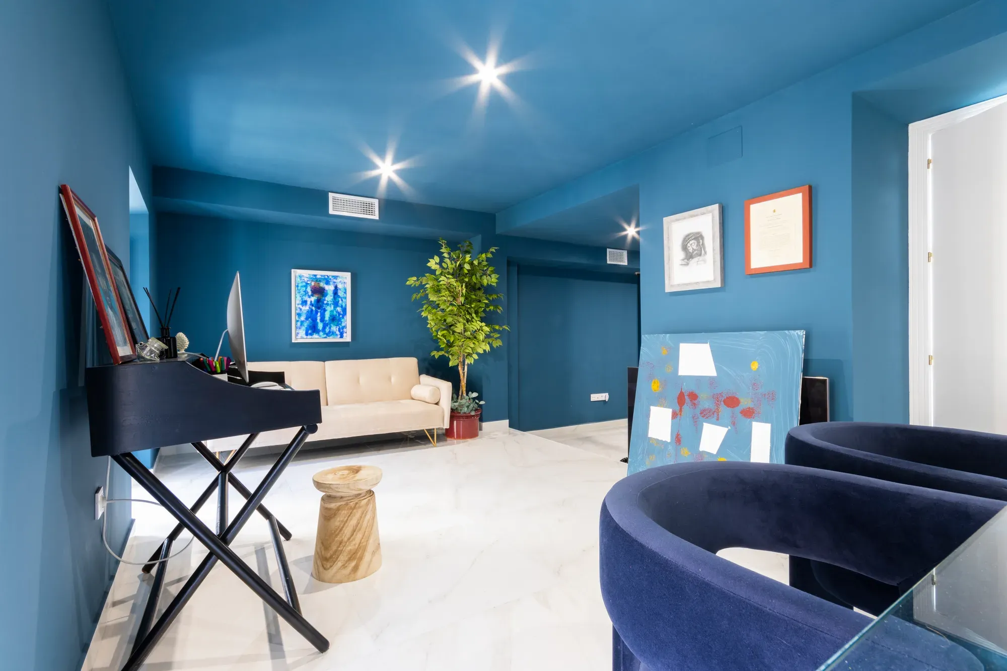 Salón reformado con las paredes y el techo en azul y un piano de cola