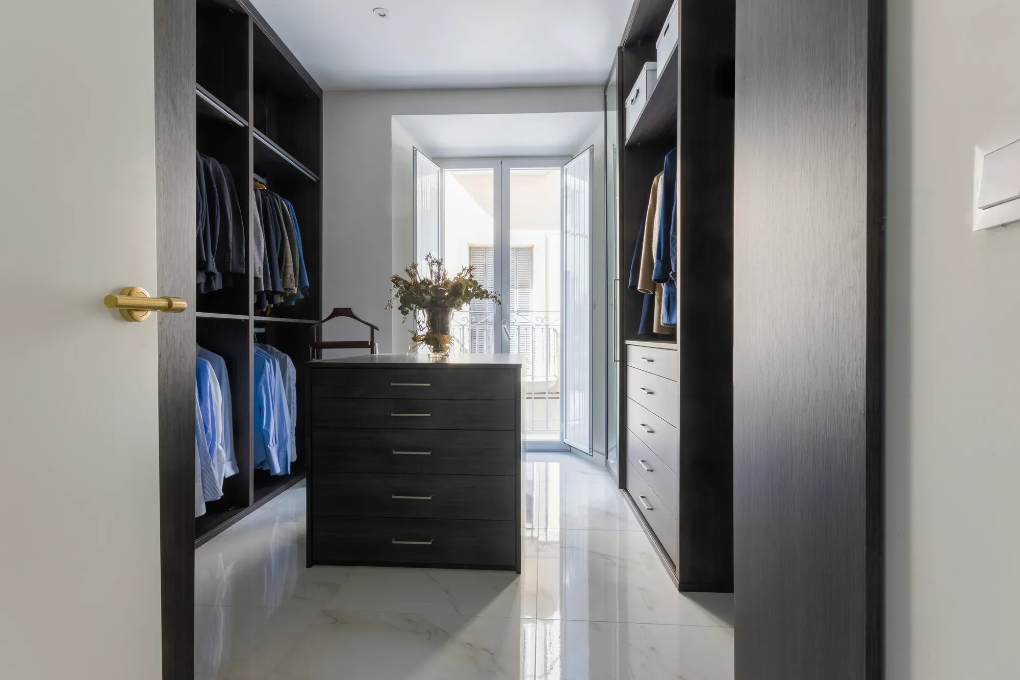 Vestidor reformado con armarios de puertas oscuras y cajonera central