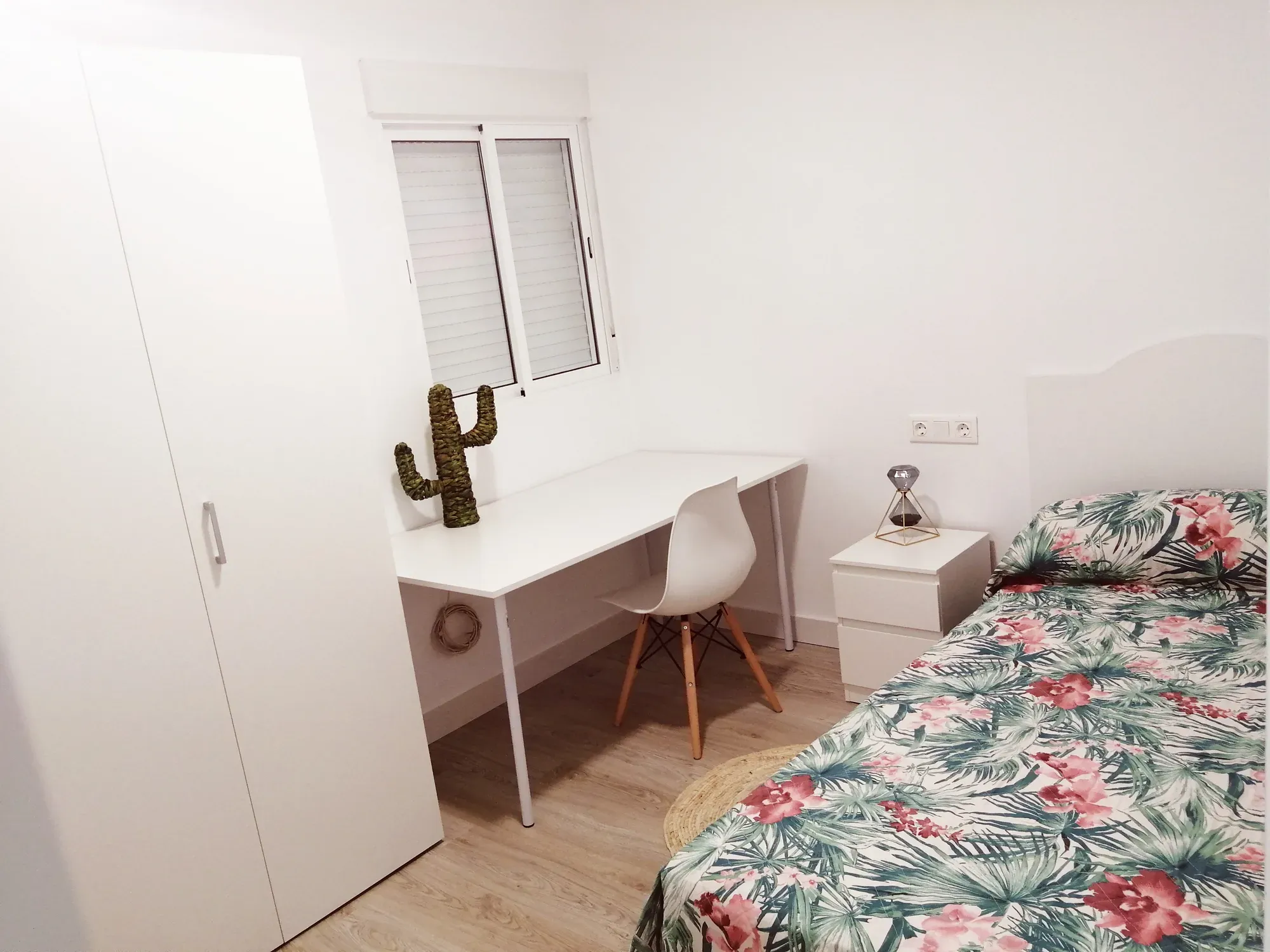 Dormitorio reformado con armario empotrado y escritorio bajo la ventana