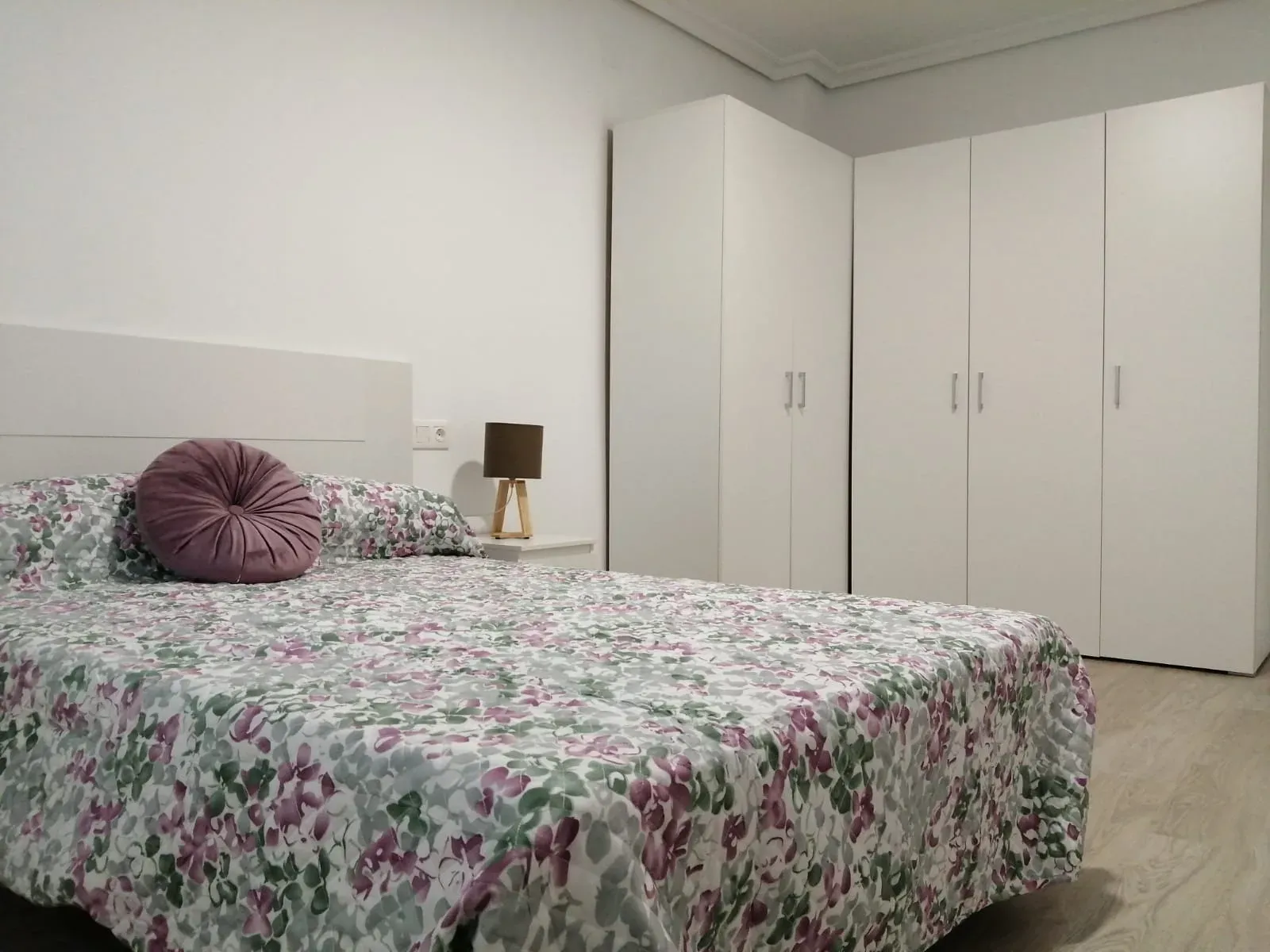 Dormitorio reformado con suelo de madera clara y armario empotrado