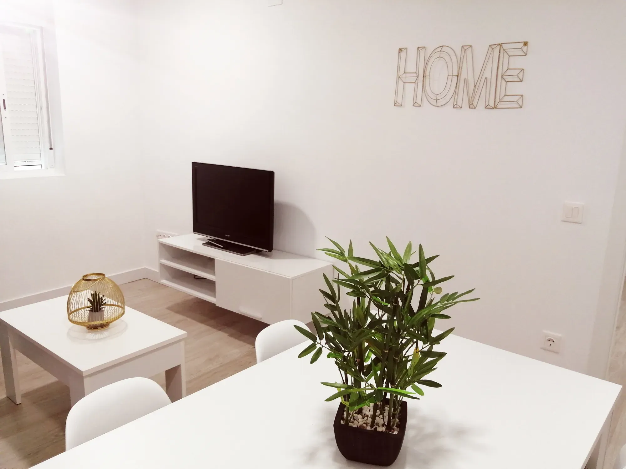 Salón reformado sencillo con mueble bajo de televisión y suelo continuo