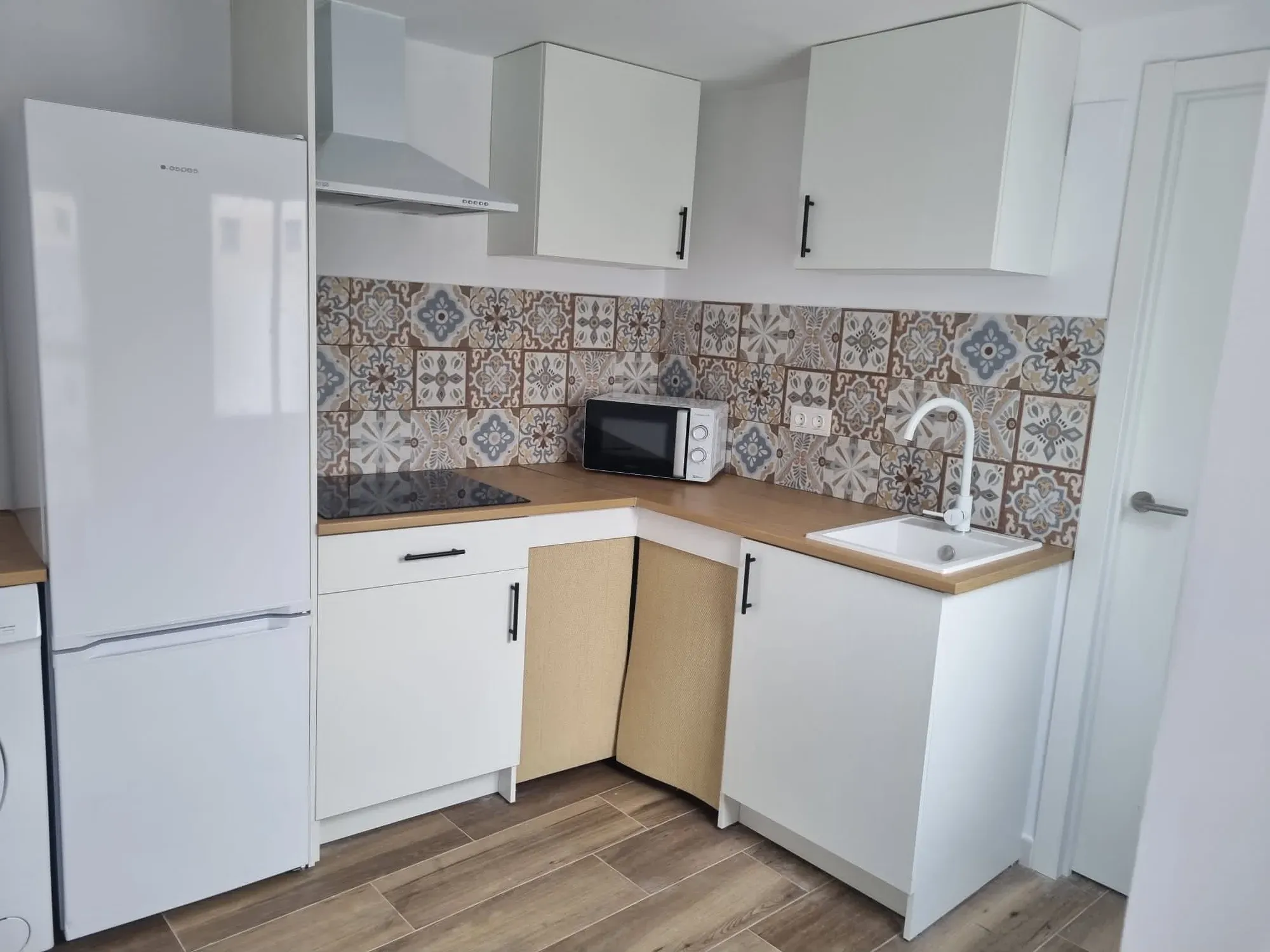 Cocina pequeña reformada con frente de azulejo hidráulico y encimera de madera